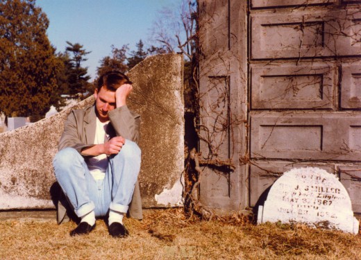 Andy sitting by a tombstone