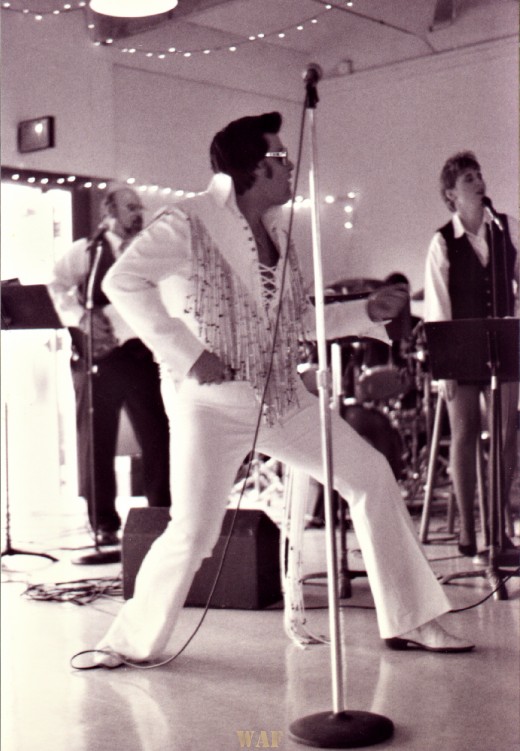 an Elvis impersonator, performing at a wedding reception