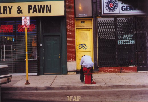 a Chicago street scene of a man sitting on a fire hydrant near a pawn shop