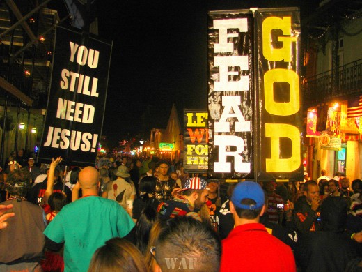 "Fear God" and "You Still Need Jesus" signs in the Bourbon Street crowd in New Orleans, LA