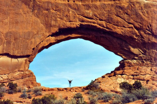 an Arches National Park (UT) arch, with Eugene standinng at it's center
